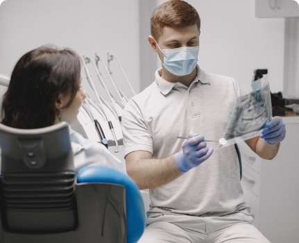 Richmond Dentist near me - Female patient looking her stomatologist shows picture oral cavity